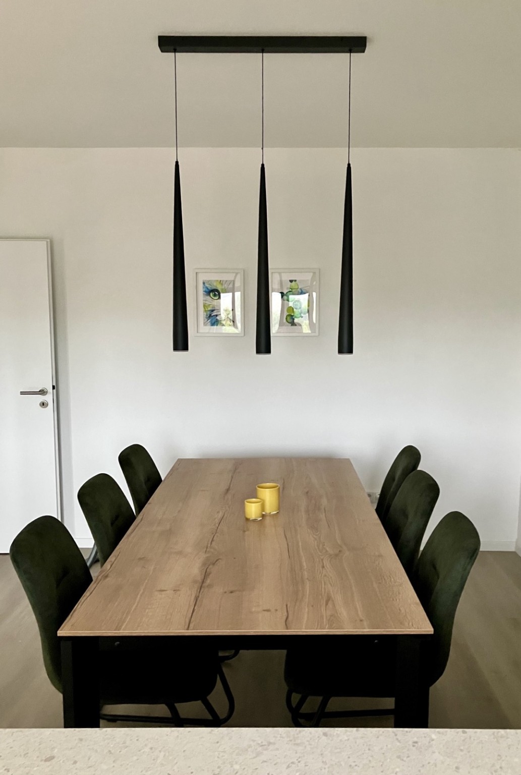 Großer Esstisch mit sechs Stühlen und moderner Pendelleuchte