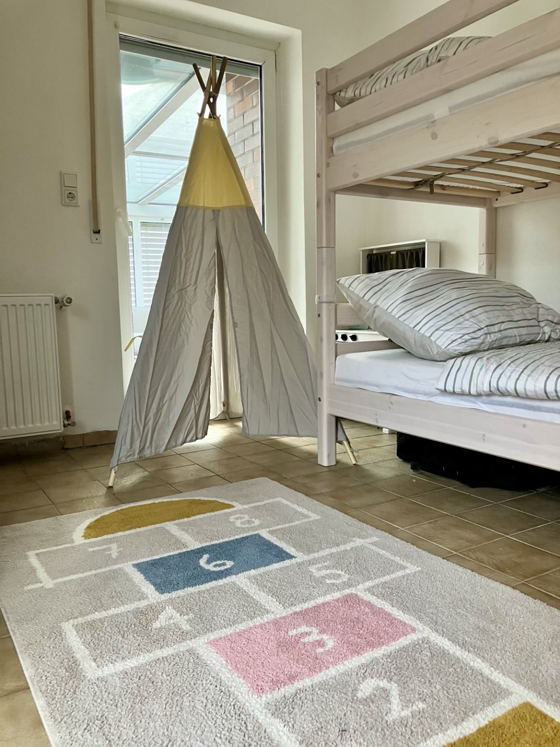 Kinderzimmer mit Hochbett, Spielzelt und Spielteppich im Ferienhaus Obersfeld