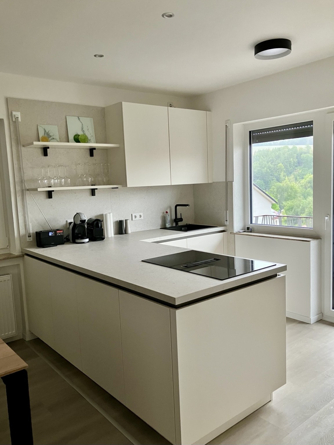 Moderne offene Küche mit Kücheninsel, Kochfeld und viel Arbeitsfläche