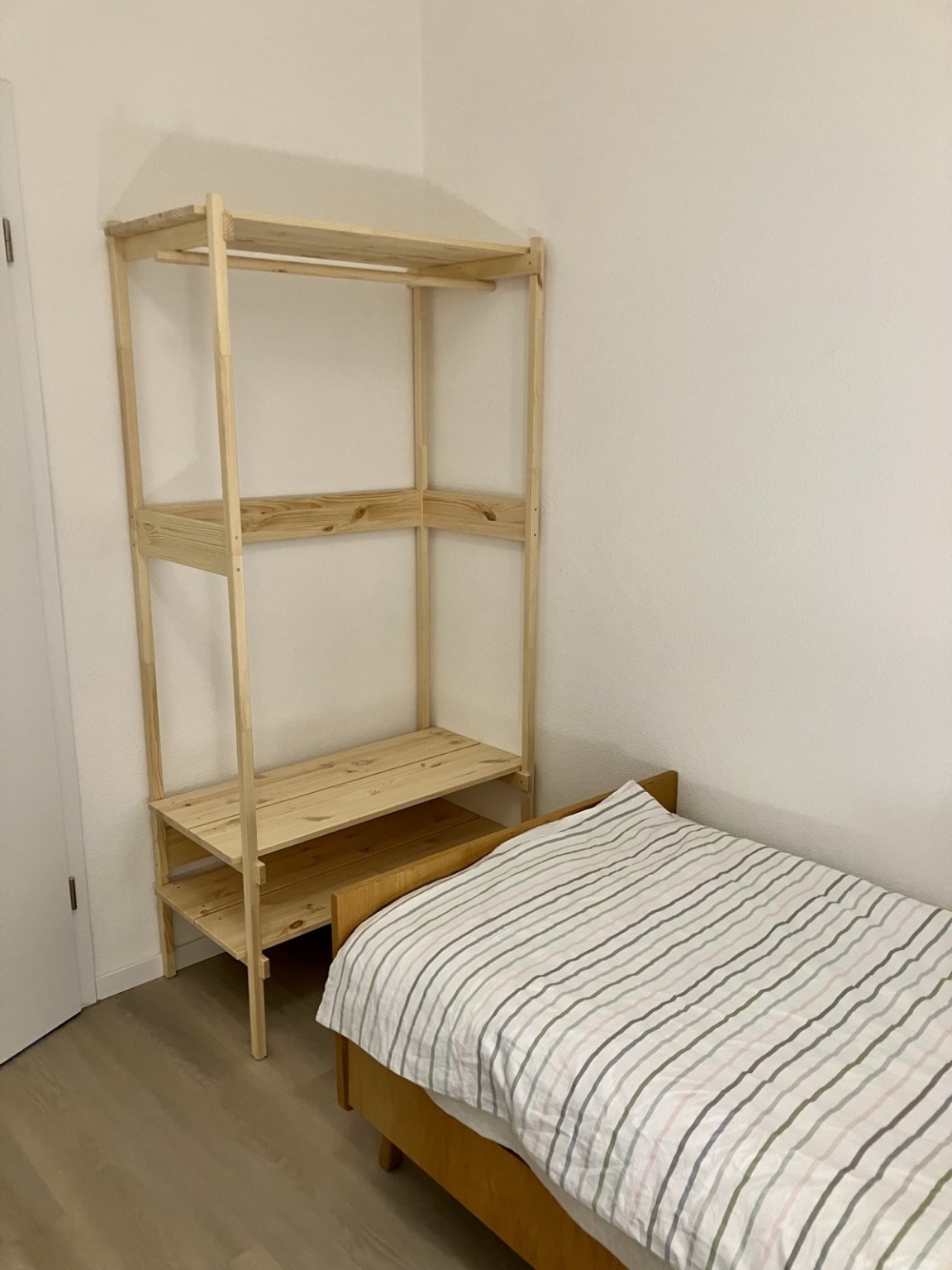 Offene Garderobe und Einzelbett im zweiten Schlafzimmer des Ferienhauses Obersfeld